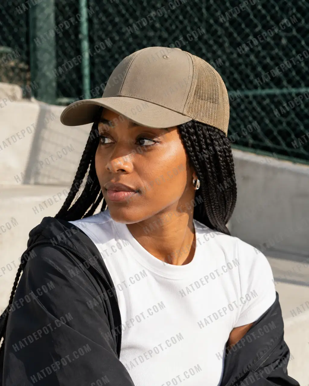 Close three-quarter view of a model wearing the khaki Curved Brim Trucker Snapback, showing its curved visor, front seam and mesh panels.